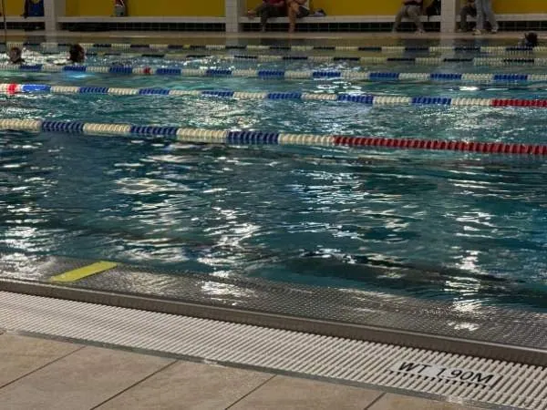 Freizeit im Schwimmbad, Pool mit Schwimmbahnen, Wasserbecken, Kinder- und Erwachsenenschwimmen, Wassersport, Schwimmtraining, Badespaß, Familienaktivität.