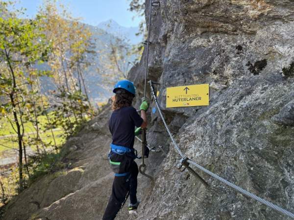 Kletterer am Felsen mit Sicherheitsausrüstung beim Wandern in den Bergen, inmitten der Natur, Abenteueraktivität, Outdoor-Sport, Alpinismus, auf dem Huterlaner-Hinweis.
