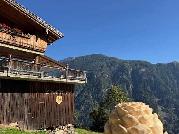 Schöner Bergblick mit rustikalem Chalet und Eiscreme im Vordergrund, perfekte Kulisse für Familienurlaub und Naturerlebnis in den Alpen.