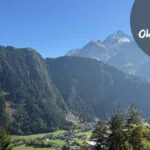 Beitragsbild mit dem Titel: 12 von 12 Oktober 205 mit einer Berglandschaft im Hintergrund und einem Holzteil links vorne