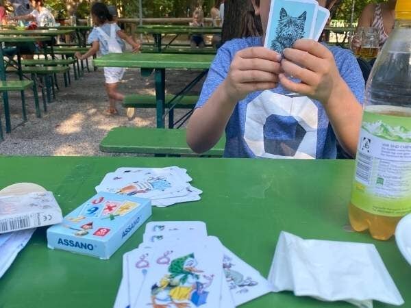 Kind das gerade Karten spielt im Biergarten