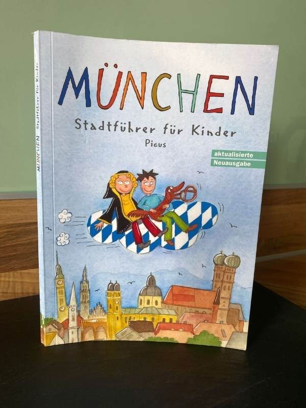 Ein Buch mit dem Cover und dem Titel "München - Stadtführer für Kinder" und einer Zeichnung von München auf dem Cover