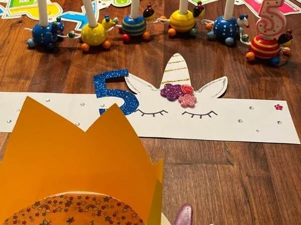Bunte Geburtstagsdeko mit Einhorn-Motiv und Kinderkerzen auf Holztafel, perfektes Party-Accessoire für Kinder Geburtstag, DIY Deko für Kinderparty, kreative Bastelideen für Kinderfeiern.