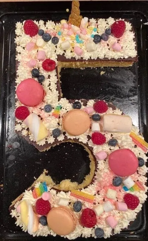 Bunte Geburtstagstorte in Form der Zahl 5 mit bunten Marshmallows, Beeren und Dekorationen, ideal für Kinderfeste und Partydekorationen, kreative Kuchendeko für besondere Anlässe.