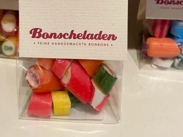 Bunte handgemachte Bonbons in einer transparenten Verpackung, perfekt für Naschmomente und als Geschenk, hochwertiges Süßwaren-Design.