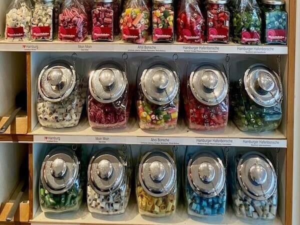 Verschiedene bunte Süßigkeiten in dekorativen Gläsern, perfekt als Geschenk oder zum Naschen für Kinder und Erwachsene.