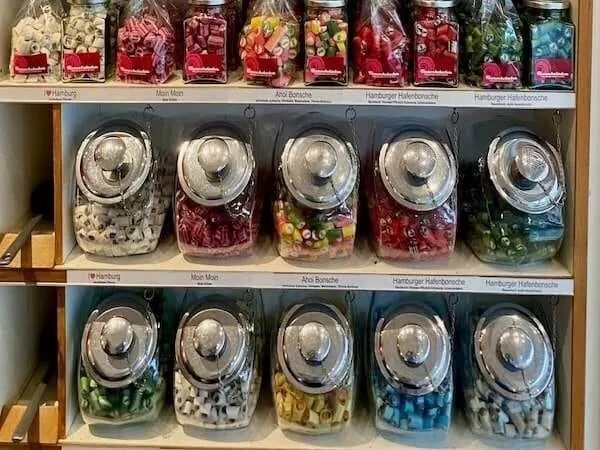 Verschiedene bunte Süßigkeiten in dekorativen Gläsern, perfekt als Geschenk oder zum Naschen für Kinder und Erwachsene.