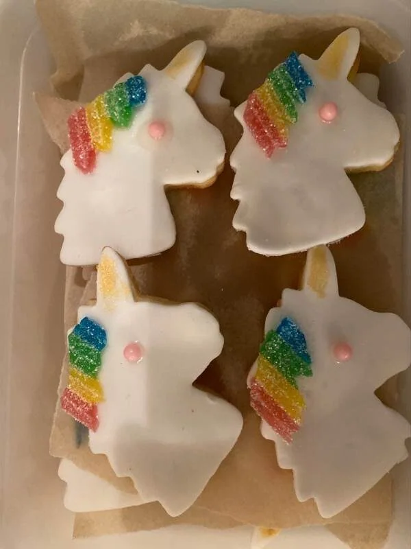 Einhorn-Kekse mit weißer Glasur, buntem Zuckerguss und rosa Dekor, perfekt für Kindergeburtstag und Feierlichkeiten.