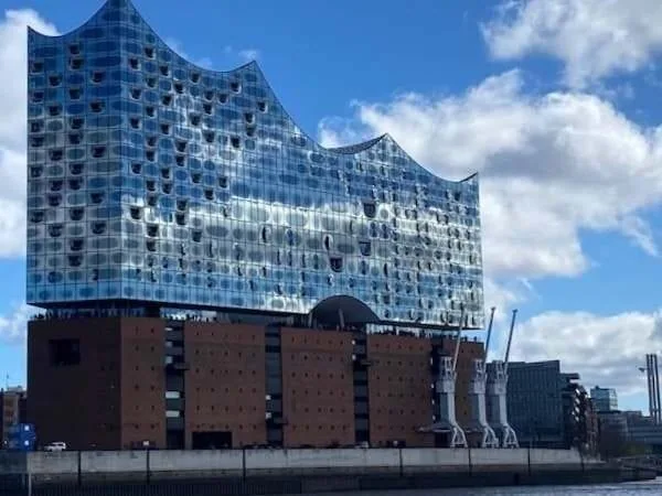 Moderne Architektur mit reflektierendem Glasdesign in Hamburg, Deutschland, bei sonnigem Himmel.