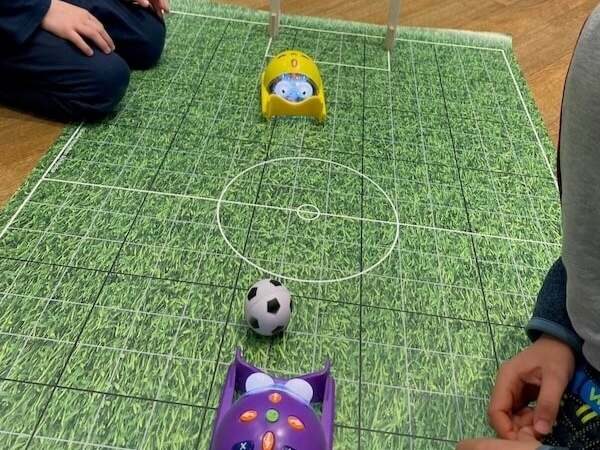 Spielende Kinder beim sicheren Fußballspiel mit elektronischer Tischfussball-Anlage für Kinder, Indoor-Fußballspiel Breitbild.