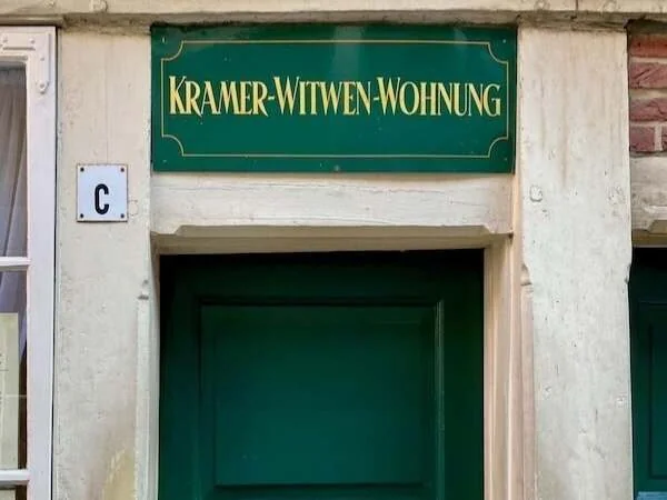 Historisches Wohnhaus in Deutschland mit grüner Tür und Schildern, alten Steinelementen, typisch für charmante Altbauten, liebevoll renoviert für Familien oder Historienfans.