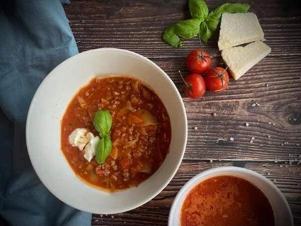 Frische Lasagnesuppe mit Basilikum und Brot auf Holz Tisch, vegetarisches Gericht, comfort food, gesund, glutenfrei, schnelle Mahlzeit, hausgemachte Suppe, Tomatensauce, sommerliche Küche, italienische Küche.