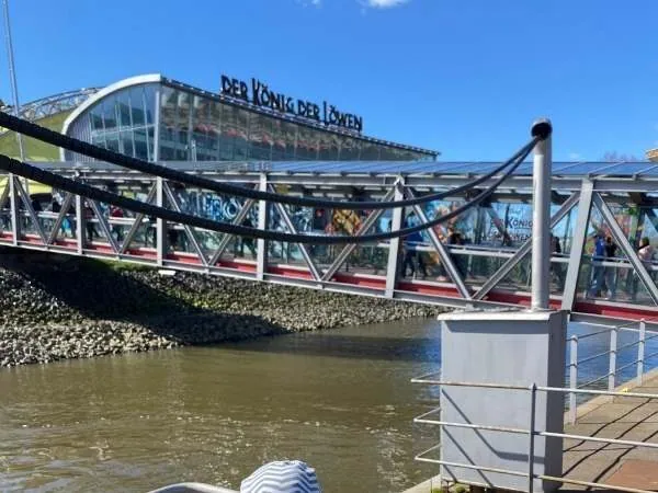 Innovativer Fußgängersteg vor dem Theater des Königs der Löwen, an einem sonnigen Tag, ideal für Familien und Theaterliebhaber, in Berlin, Deutschland.