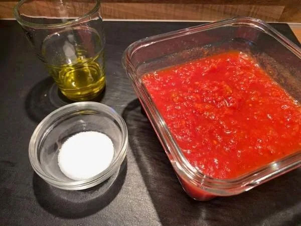 Zutaten für die Tomatensosse für die Pizza: Tomaten gehackt im Glas, Olivenöl im Glas, Salz in einer kleinen Schüssel
