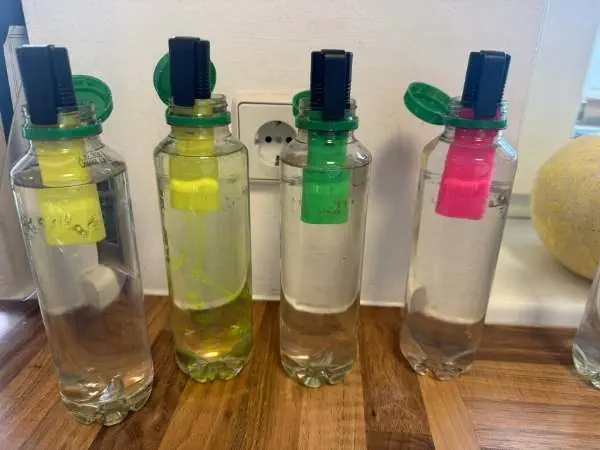 Flaschen mit Wasser und Leuchtstift dran geheftet