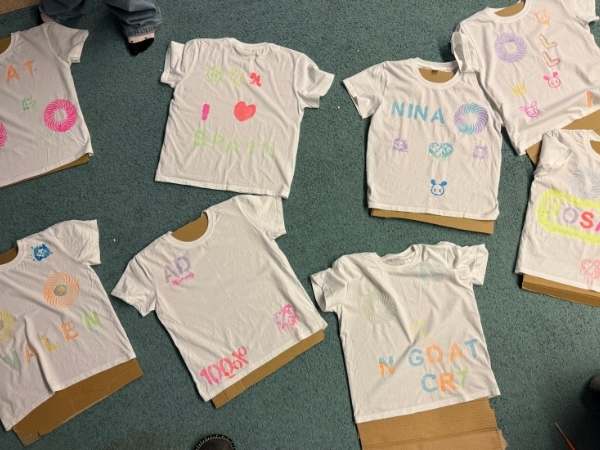 Bunte T-Shirts mit Namen und Motiven mit Glow in the Dark Farben aufgemalt