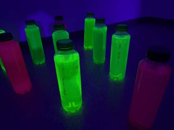 bowlingflaschen die im schwarzlicht in verschiedenen Farben leuchten