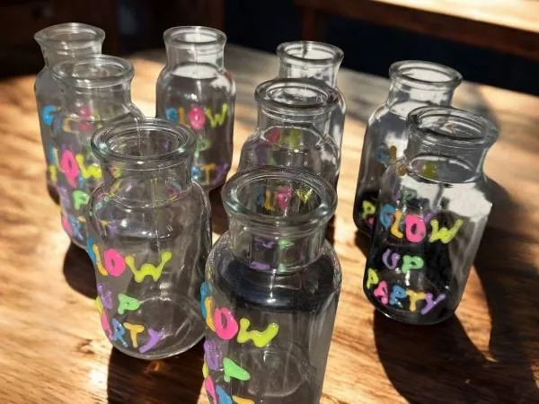 Bunte, dekorative Fläschchen mit "Follow Your Dreams" Schriftzug, ideal als kreative Dekoration oder Geschenk für Kinder und Babys, liebevoll gestaltet.