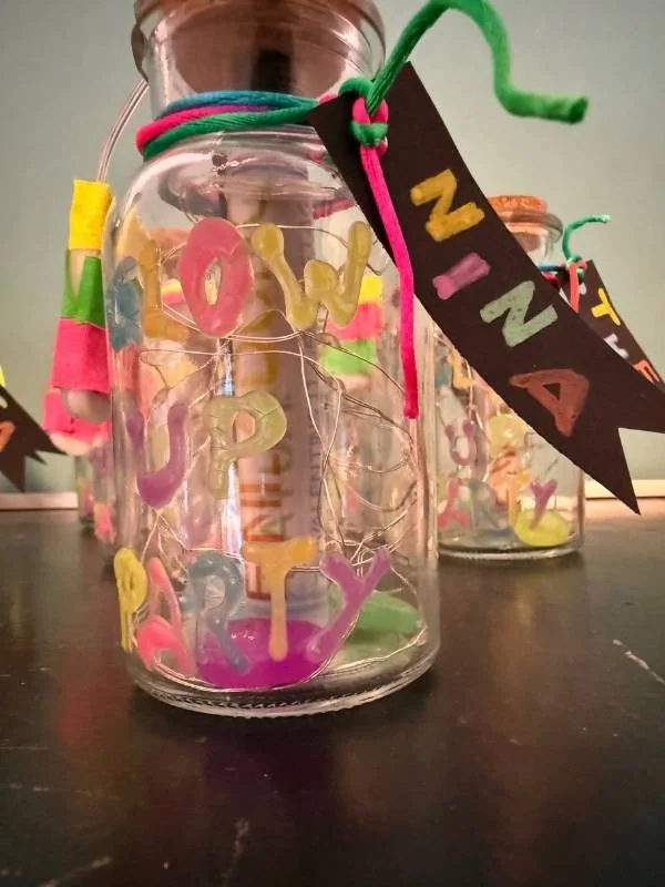 Glasflaschen mit bunten Buchstaben