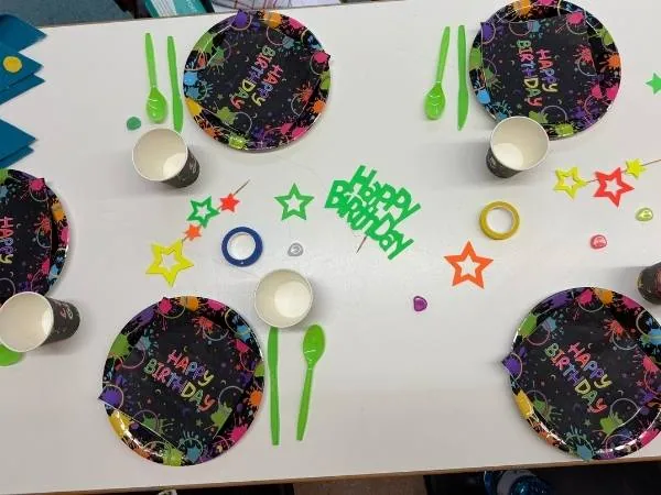 gedeckter Tisch mit Teller und Becher zum Motto Neon Party