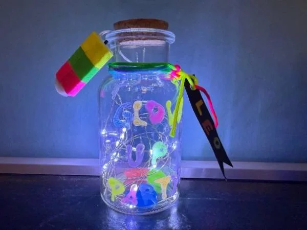 Glühendes Glas mit bunten Buchstaben