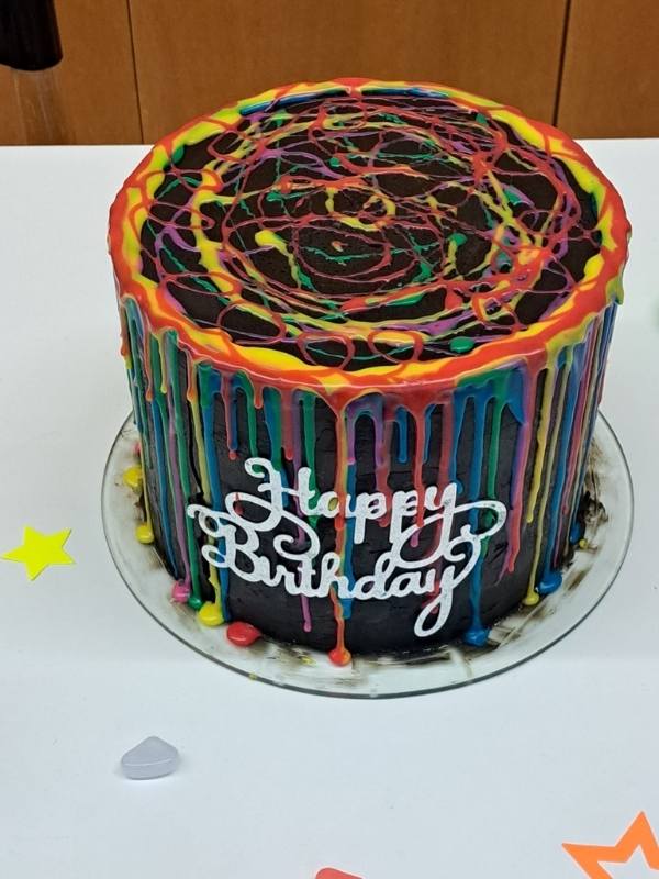 Torte mit Happy Birthday Schriftzug. Gro&szlig; und Rund Un mit Neon Glasur in verschiedenen Farben.