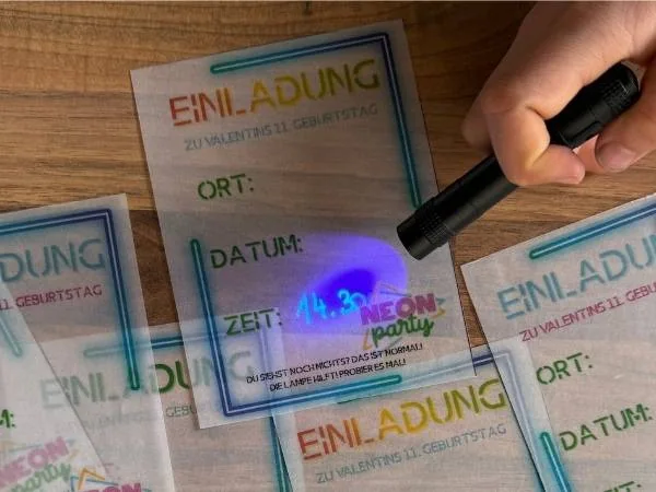 Einladungskarten mit UV-Lampe beleuchtet