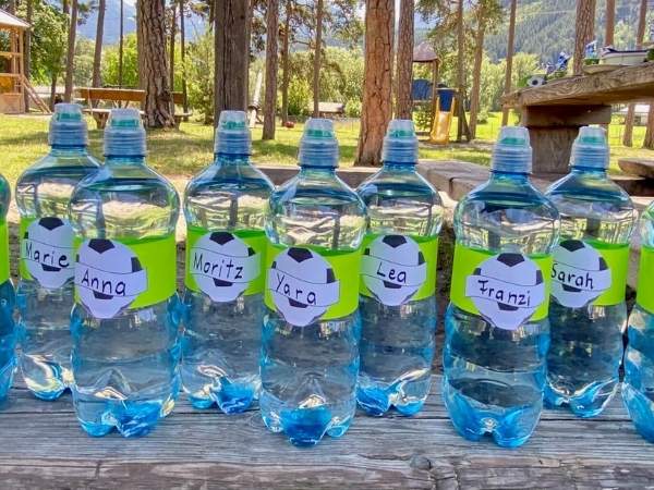 Flaschen mit Etiketten mit einem Fußball und dem Namen der Kinder darauf