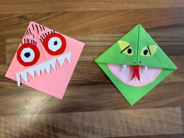 2 kleine Eckenmonster-Lesezeichen in grün als Schlange und in rosa mit roten Augen und vielen Zähnen