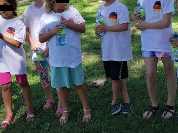 Kinder mit ihren selbst angemalenen Fußballshirts stehen auf der Wiese bei dem Fußball Geburtstag