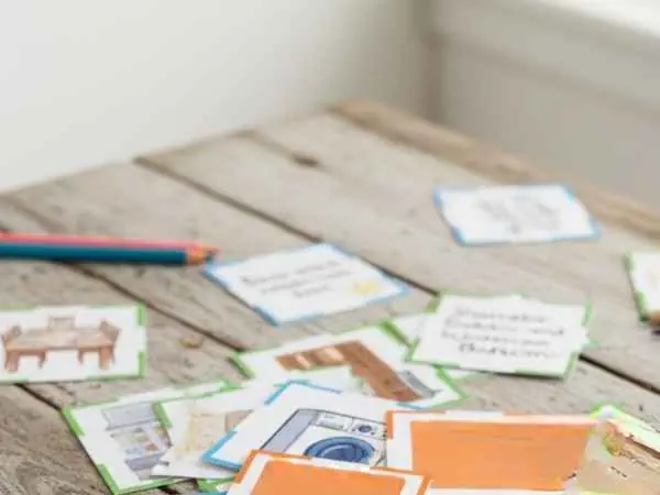 Bunte Spielkarten und Notizen für Schatzsuche auf einem Holztablett, geeignet für Kinder und Familien, im Rahmen der "Salespage 10-Minuten-Schatzsuche".