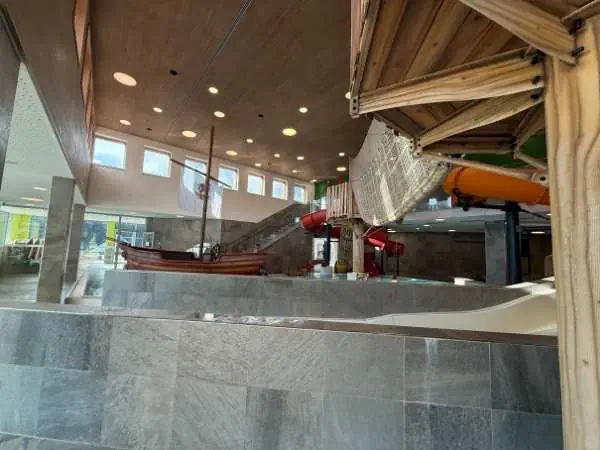 Ein Indoor-Wasserpark mit Wasserrutschen, Wasserbecken und Spielbereichen für Kinder, ideal für Familien und Freizeitgestaltung.