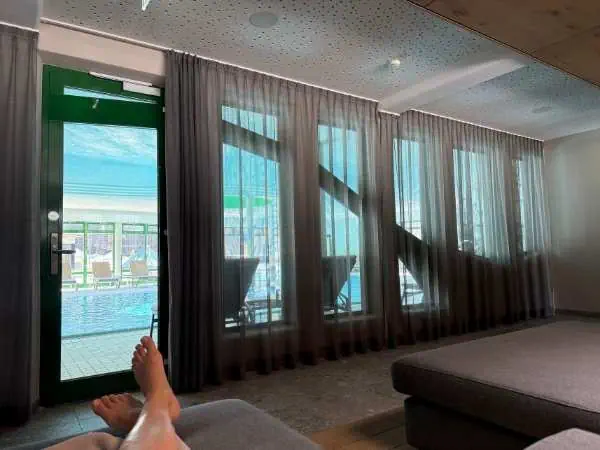 Entspannter Blick auf den Indoor-Poolbereich mit großen Fenstern und Tageslicht, ideal für Familien und Erholung, perfekt für Mama-Blog-Inhalte.