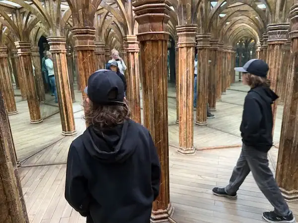 Kind, das in einem Spiegellabyrinth geht und man von verschiedenen Seiten aus sieht