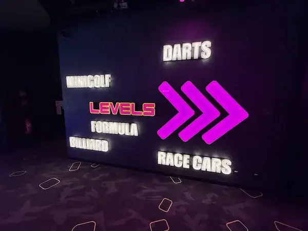 Leuchtendes Neon-Schild mit Aktivitäten für Familien in Prag, inklusive Minigolf, Darts, Rennwagen, Formel, Billard und mehr, ideal für Familienausflüge in der tschechischen Hauptstadt.