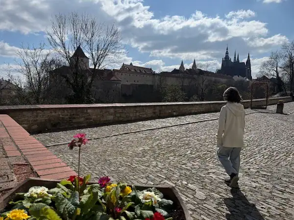 Kind erkundet die historische Prager Burg mit Blick auf die Skyline, ideal für Familienaktivitäten in Prag, Tschechien, bei einem 5-Tage-Urlaub mit Kindern.