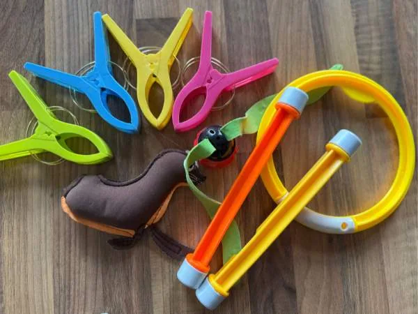 Bunte Wäscheklammern, Spielzeug und ein Spielzeug-Set für Kinder auf Holztisch, geeignet für Baby- und Kleinkindspielzeug, fördert motorische Fähigkeiten und Kreativität.
