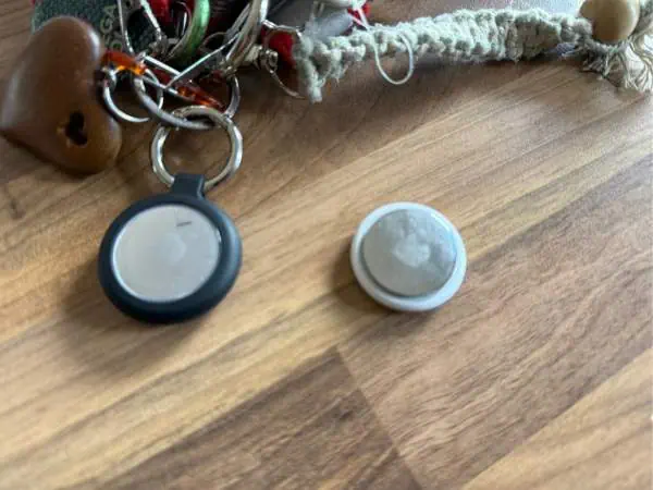 Schlüsselanhänger mit Baby- und Mutter-Accessoires, inklusive Schnullern und Spielzeug, auf Holztisch, symbolisiert Elternschaft und Familienleben.
