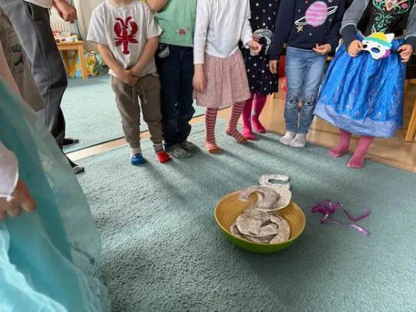 Kinder beim Spielen mit einem Fisch- und Seilspiel im Kindergarten, Spaß und Gemeinschaft, kindgerechte Aktivitäten, pädagogische Betreuung, spielerisches Lernen, Eltern-Kind-Interaktion, kreative Fre.