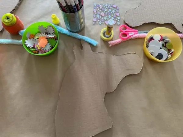Kreatives Bastelset für Steckenpferde am Kindergeburtstag, inklusive Filz, Schere, Kleber, Dekorationen und Vorlage für eine einfache DIY-Anleitung.
