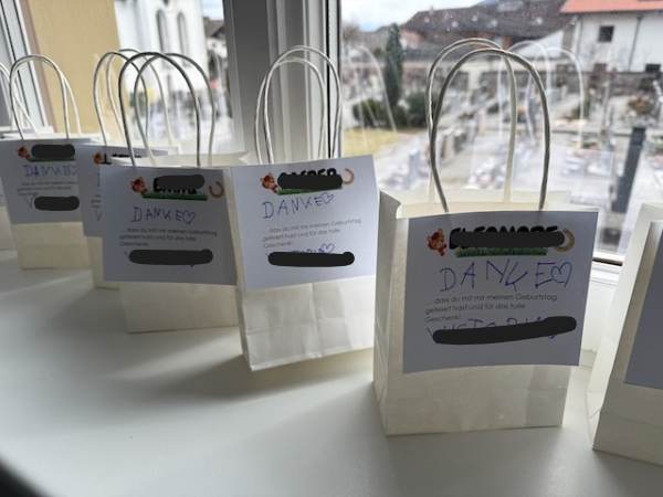 Kleine wei&szlig;e Geschenktaschen mit handgeschriebenen Dankesbotschaften und Herzsymbolen, ideal f&uuml;r pers&ouml;nliche Geschenke oder Dankesgeschenke.