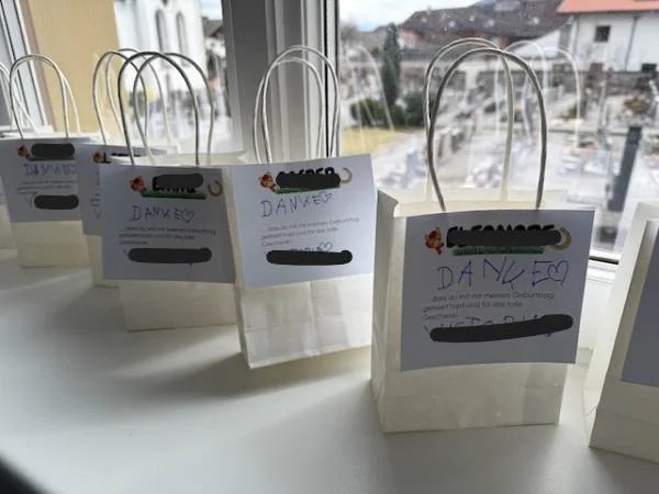 Kleine weiße Geschenktaschen mit handgeschriebenen Dankesbotschaften und Herzsymbolen, ideal für persönliche Geschenke oder Dankesgeschenke.