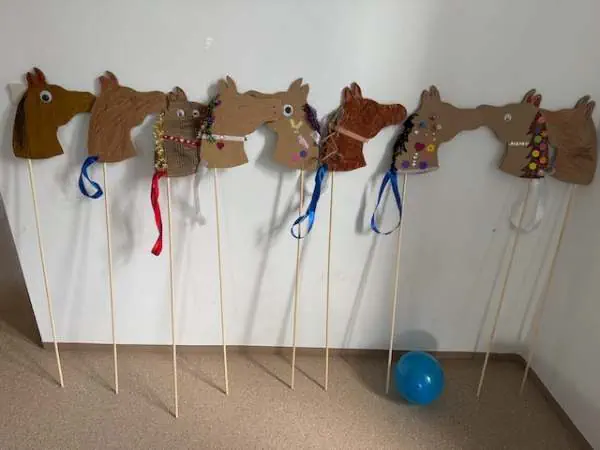 Bunte Steckenpferde aus Filz und Holzstäbchen, perfekt für kreative Kindergeburtstagsaktivitäten, einfache Bastelanleitung mit Vorlage für lustige Pferdefiguren.