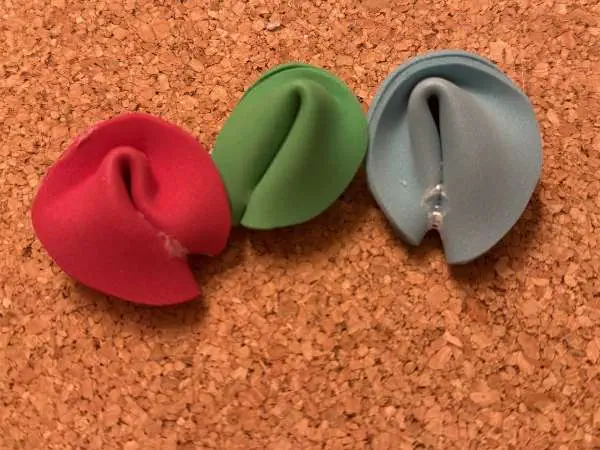 Drei fertige Glückskekse aus Moosgummi mit Spruchzettel in Rot, Grün und Grau