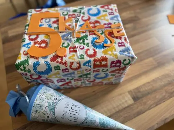 Eingepacktes Geschenk zur 5. Klasse mit ABC-Geschenkpapier und kleiner Schultüte