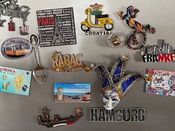 Charmante Souvenirsammlung mit Reisezubehör und Souvenirs aus Kroatien, Frankreich, Irland und Hamburg, inklusive Schlüsselanhänger, Magneten, Miniaturfahrzeugen und einer venezianischen Maske.