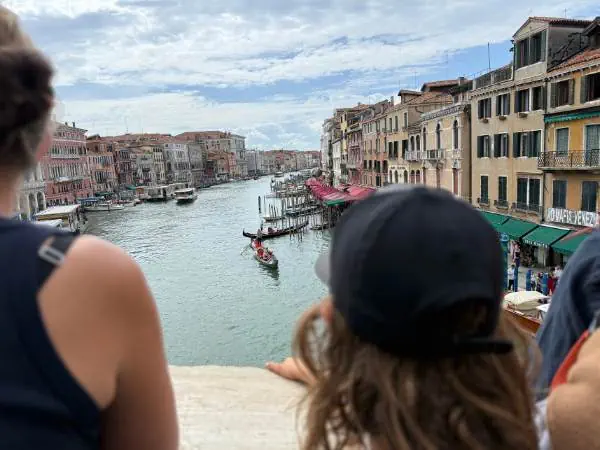 Entspannter Blick auf den Canal Grande in Venedig mit historischen Gebäuden, Gondeln und Touristen, ideal für Familien- und Reiseblog.