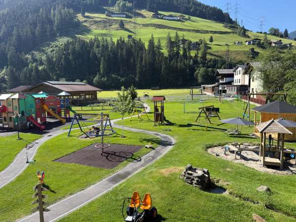 Spielplatz im Kinderhotel Felben mit Fahrzeugen und Spielgeräten
