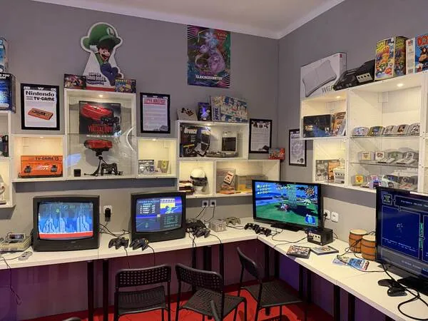 Innenraum des Gaming Museums mit alten Konsolen und laufenden Retro-Spielen auf Röhrenfernsehern