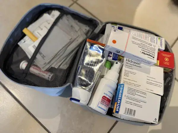 Geöffnete Reiseapotheke mit Medikamenten, Pflastern und Desinfektionsmittel für die Südafrika-Reise mit Kindern